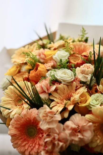 A close-up of a floral bouquet delivered by flowers at flowerdeliverymaldenrushett.co.uk for a wedding occasion. The arrangement features an assortment of fresh, pastel-colored flowers including peach