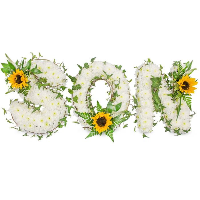A three-dimensional sympathy tribute spells out SON in bold capitals, each letter densely faced with hundreds of small, immaculate white chrysanthemums that form a soft, tactile plane. The chrysanthemums' clustered button heads present a serene, satin-like surface that reads as purity and calm. Interlaced through this white foundation are dark green ivy stems, their characteristic lobed leaves curling and weaving around letter edges to add structural rhythm and a living, evergreen note; lighter green fern fronds and pointed foliage give additional layers of texture and a natural, botanical frame. To introduce warmth and a focal rhythm, three sunflowers with vivid yellow rays and pronounced dark brown centres have been positioned deliberately: a prominent sunflower rests on the upper left curve of the S, a second sits low and central within the O amid fern tendrils, and a third adorns the upper right of the N. Against a stark white photographic background and under soft studio illumination, the contrast between the chrysanthemums' soft whiteness, the sunflowers' golden glow and the deep greens of the foliage is striking and deeply readable. As a florist serving the Malden Rushett area and neighbouring communities such as Chessington and New Malden, I assemble these personalised floral words for funeral services and memorial displays; the composition balances the serenity of traditional bereavement flowers with the hopeful brightness of sunflowers, conveying both sorrow and a quiet celebration of life. The piece feels both crafted and intimate, appropriate for those seeking a meaningful tribute for a beloved son.